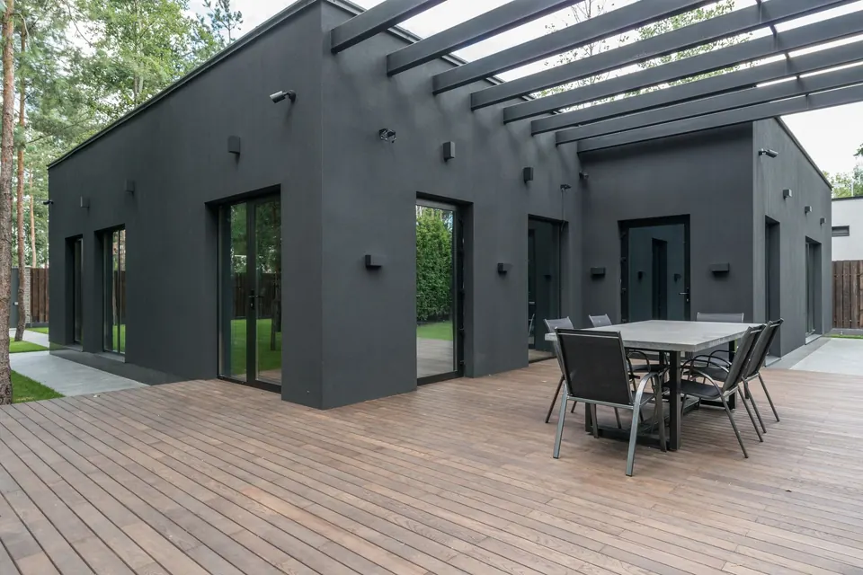 Maison de plain-pied à toit plat, terrasse en bois et pergola