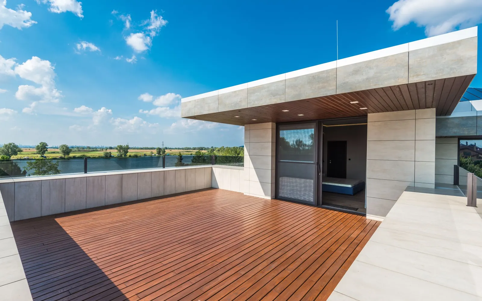 Toit-terrasse accessible d'une maison contemporaine, platelage bois et garde-corps vitré